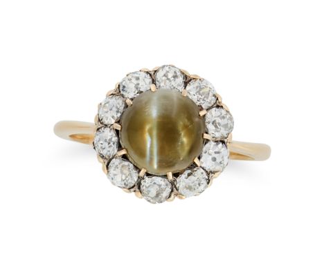AN ANTIQUE CAT'S EYE CHRYSOBERYL AND DIAMOND CLUSTER RING in yellow gold, set with a round cabochon cat's eye chrysoberyl in 
