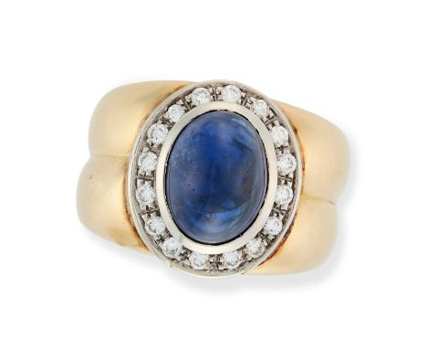 A SAPPHIRE AND DIAMOND CLUSTER RING in 18ct yellow and white gold, set with an oval cabochon sapphire of approximately 7.01 c