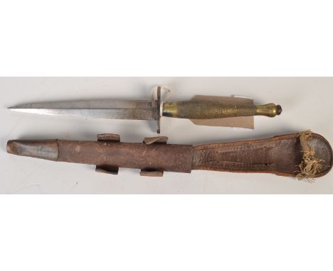 A WWII Wilkinson Sword Fairburn Sykes 2nd pattern Fighting Knife with hatched brass hilt, the original leather sheath with co