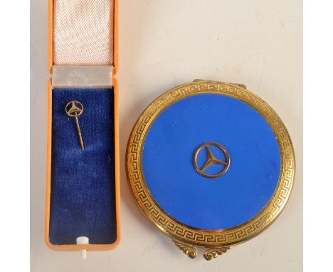 A Mercedes stick pin and a Mercedes powder compact.