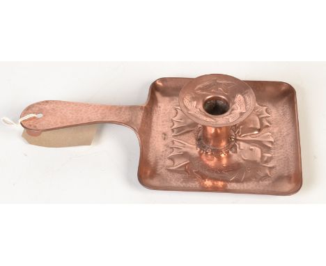 A Newlyn Copper square shape chamber stick the tray base relief decorated with confronting fish, the detachable drip pan reli