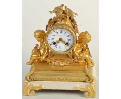 A French gilt metal mantle clock, mounted with a pair of love birds, to either side, a putti holding a garland.