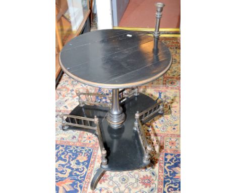 A Victorian ebonised book table with circular top and candlestick on a turned pedestal, a low shelf with open galleried book 