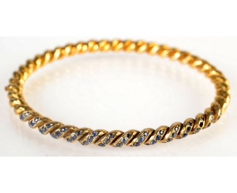 A French, high purity spiral gold hinged bangle, set with sapphires.