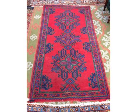 An eastern red ground hand knotted carpet runner, pattern with a geometric design, within a patterned border, 107 x 200cm app