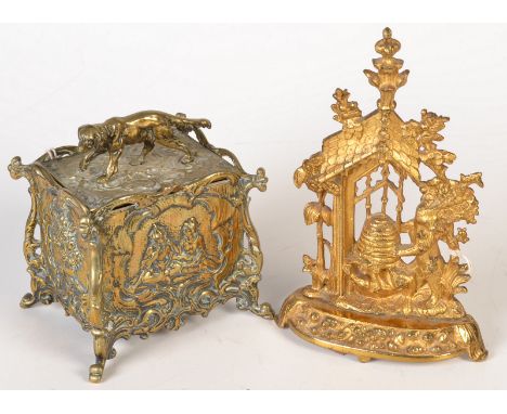 A Victorian gilt brass hearth ornament cast with bears stealing honey from a skep, together with a cast metal tea caddy with 
