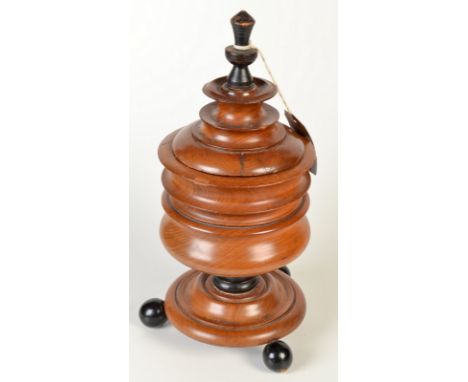 A 19th century continental turned walnut lidded tobacco jar, standing on three ebonised ball feet, height including finial 34