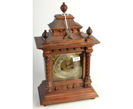 A continental walnut case mantle clock, with a brass dial in an architectural case. 