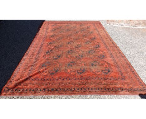 A Turkoman, red ground carpet with three row of six guls, 440 x 284cm.