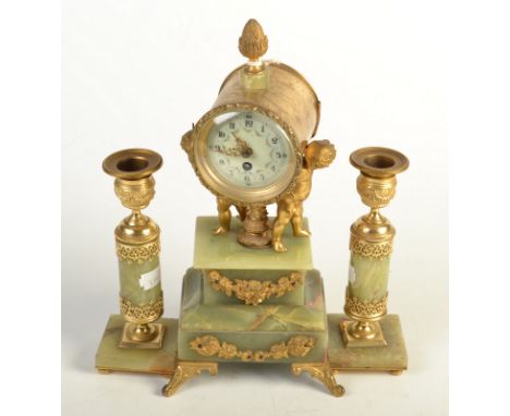 An ormalu and onyx clock garniture, the timepiece supported by cherubs flanked by candlesticks.
