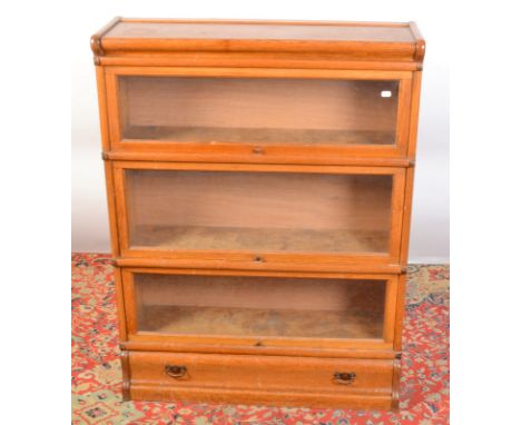 A light oak Globe Wernicke type four tier bookcase incorporating a low drawer, width 87cm, height 115cm.