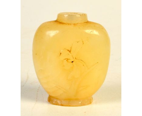 A carved jade or other hard stone snuff bottle, one side with iris, the other prunus, height 4.6cm