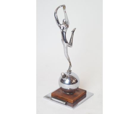 An Art Deco chrome plated desk lighter Modelled with a nude dancing girl with out swept arms, raised on a circular ball, term