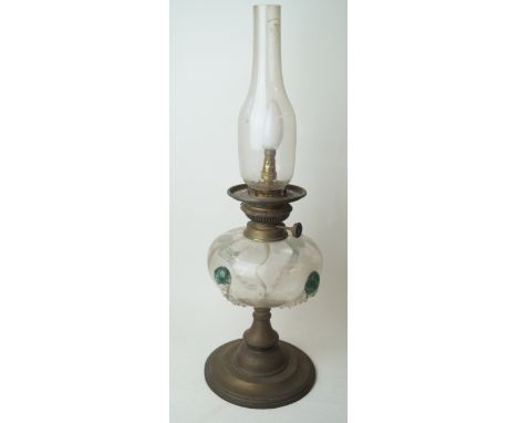 An Art Nouveau glass oil lamp in the manner of Stuart and SonsThe clear glass reservoir having four green and blue applied ro