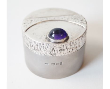 A contemporary hallmarked silver patch box and coverOf circular form, the cover having cast stylised decoration with a single
