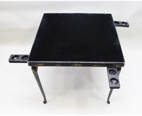 A 20TH CENTURY EBONISED CHINOISERIE DECORATED CARD TABLE with slender folding supports, having combined ashtrays and glass ho