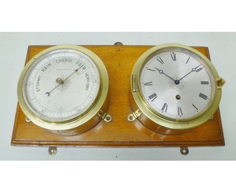 AN EARLY 20TH CENTURY SHIP STYLE BRASS BINNACLE MOUNTED TIME PIECE with matching barometer, silvered dials, each 15cm diamete