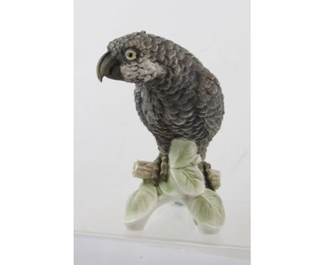 A 20TH CENTURY HAND DECORATED GOEBEL PORCELAIN MODEL OF AN AFRICAN GREY PARROT perched on a leafy branch, model no. CV79 date