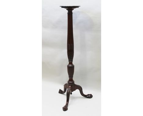 A 20TH CENTURY MAHOGANY TORCHERE, the dished top on fluted carved pedestal with tripod supports, terminating on ball and claw