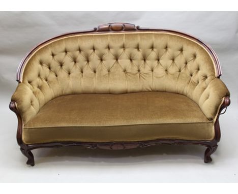 A VICTORIAN MAHOGANY FRAMED SOFA, scroll front arms terminating in shaped front supports, in deep gold button back fabric uph