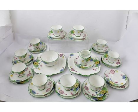 AN ART DECO PART TEA SERVICE, transfer outline design, hand coloured flowers comprising ten cups, twelve saucers, eleven tea 