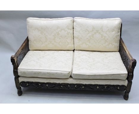A LATE VICTORIAN STAINED BEECH FRAMED THREE PIECE BERGERE DRAWING ROOM SUITE, carved decoration comprising sofa and pair of a