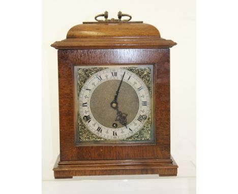 A MID 20TH CENTURY MAHOGANY CASED MANTEL CLOCK of Georgian bracket design, having caddy top case with cast brass carrying han