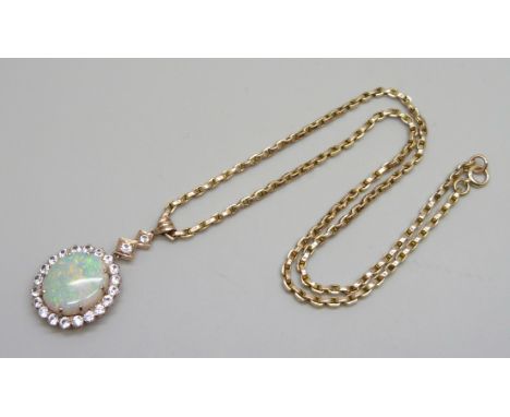 A yellow metal cluster drop pendant set with a central opal and white stone border, on a 9ct gold chain, opal 15mm x 18mm, ch