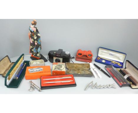 Assorted items including pens, a Kodak camera, pocket meter, folding opera glasses, Minx car badge, etc.