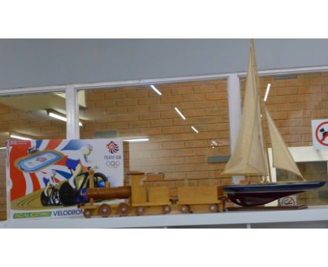 A wooden model of a yacht, a wooden toy train and a Team GB Scalextric Velodrome cycling set