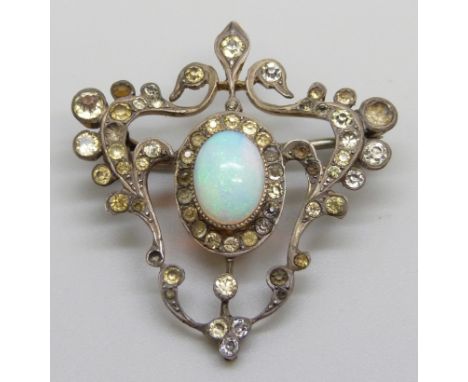 A silver Art Nouveau brooch set with paste stones and a central opal, some stones lacking