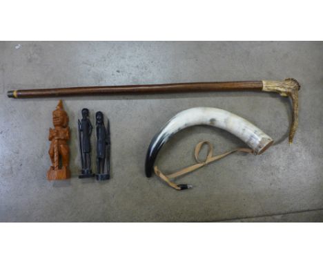 A horn handled walking stick, another horn with leather strap and three carved wooden figures