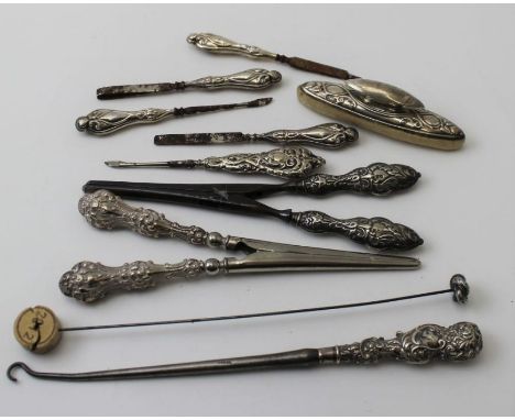 A silver hat pin, nail buffer, button hooks, glove stretchers, etc.