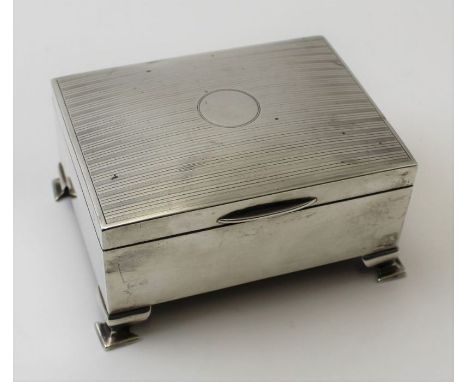 A &amp; J Zimmerman Ltd. A silver jewellery box with engine turned hinged lid, silk &amp; velvet interior, raised on ogee bra