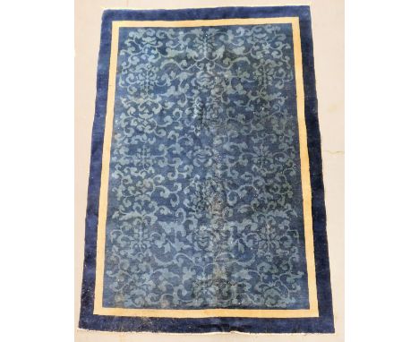 A Chinese blue ground rug, with floral and foliate scroll decoration, within cream and dark blue borders, 270cm x 177cm.