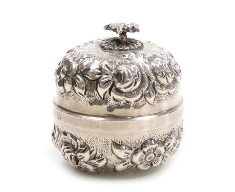 A Continental cylindrical box and cover, white metal, embossed with bands of flowers, with floral finial, stamped MA 700, 4.9