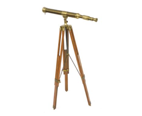 A brass single draw telescope, on a wooden and brass mounted tripod base, telescope 73cm long, stand 108cm high.