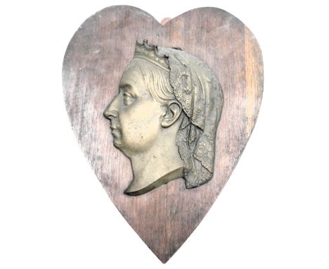 A late 19thC brass sectional profile portrait of Queen Victoria, wooden shield mounted, 40cm high.