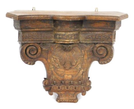 A 18thC Continental carved chestnut capital wall shelf or bracket, the capital engraved centrally with a scallop shell, benea