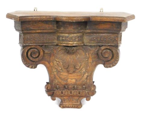 A 18thC Continental carved chestnut capital wall shelf or bracket, the capital engraved centrally with a scallop shell, benea