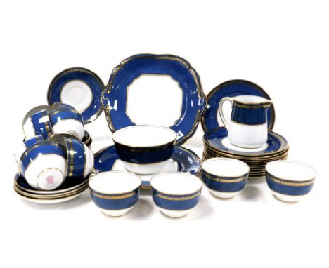 A late 19thC Paragon china porcelain tea service, decorated in gilt with a band of mistletoe on a powder blue ground, printed