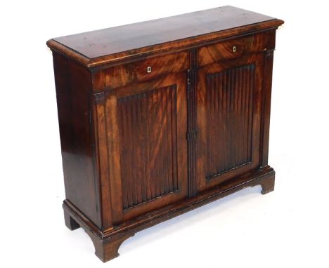 An early 19thC French mahogany side cabinet, with a pair of small drawers, over linen fold doors, opening to reveal a single 