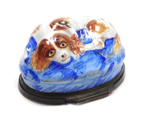 A late 18thC Bilston enamel bonbonniere, of oval form, moulded with a recumbent spaniel on a blue ground, the lid painted wit