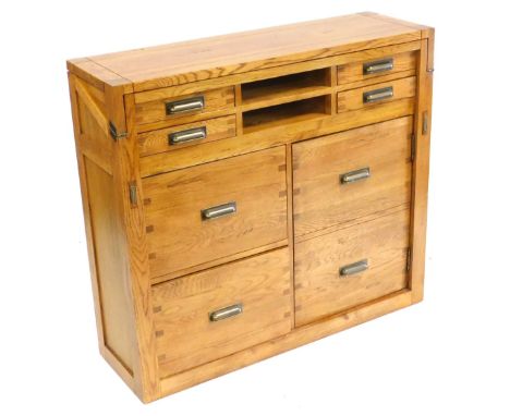 A light oak student's bureau, with a hinged writing slope, above two recesses and four short drawers, over two filing drawers