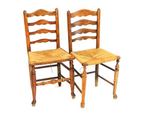 A pair of 19thC oak and rush seated ladder back country dining chairs. 