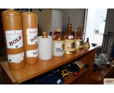 A collection of Wade bells, Scotch whiskey decanters lacking contents and various other stone bottles