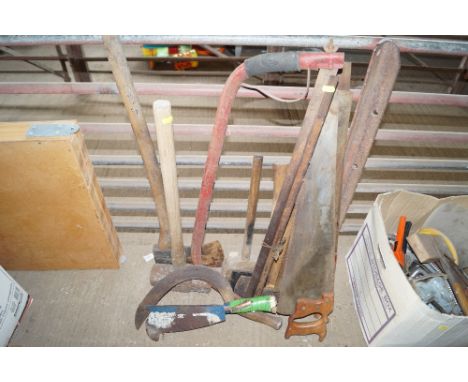 A quantity of various tools to include an axe; various hand saws; hammers etc