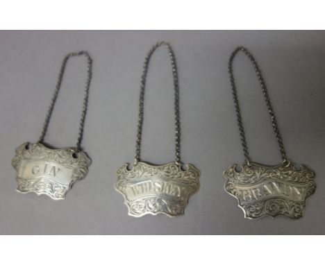 A pair of Victorian silver decanter labels, each of cartouche shaped form, detailed Brandy and Gin, by George Unite, Birmingh