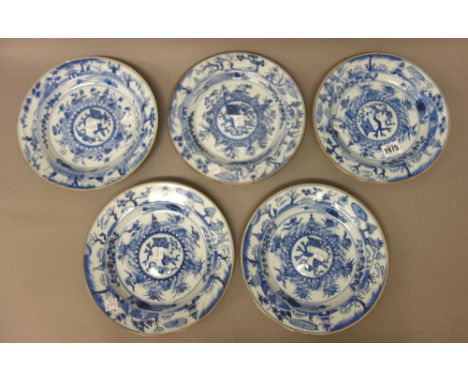 Five Chinese blue and white plates, Kangxi, each with a raised central panel enclosing a scroll, vase and prunus, inside a bo