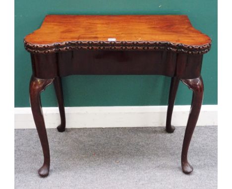 A George II mahogany card table, with shaped fold out top, on cabriole supports and pad feet, 81cm wide x 74cm high x 39cm de